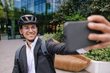 Scooter 'da selfie. Gülümseyen iş adamı mobiletle selfie çekiyor.