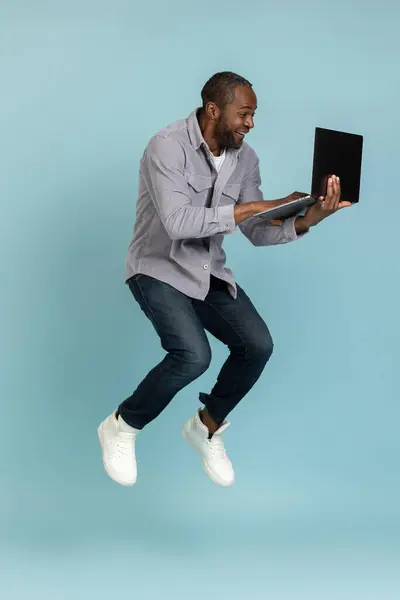 Son Derece Mutlu Gri Tişörtlü Bir Zenci Dizüstü Bilgisayara Bakıyor — Stok fotoğraf