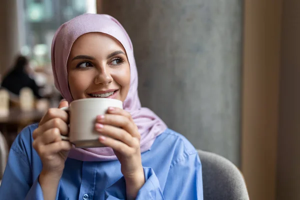 味道很好的咖啡粉红头巾的女人边喝咖啡边笑 — 图库照片