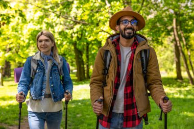 Gülümseyen gençler parkta yürümekten zevk alıyorlar.