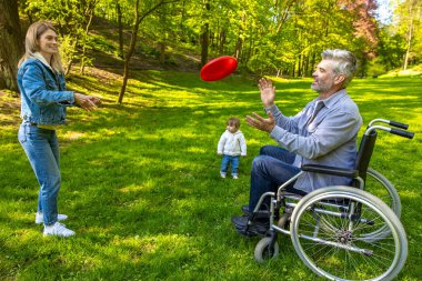 Mutlu bir aile. Ailesi ve frizbi oynayan tatlı bir çocuğu var ve mutlu görünüyorlar.