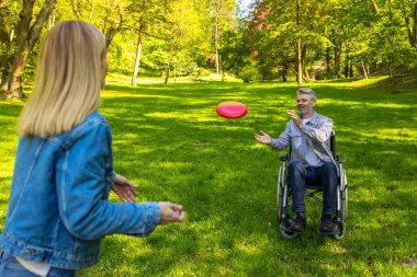 Mutlu bir aile. Ailesi ve frizbi oynayan tatlı bir çocuğu var ve mutlu görünüyorlar.