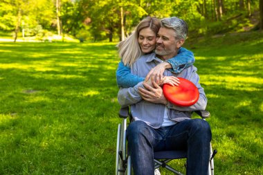 Mutlu bir gün. Sevimli bir çift birbirlerine sarılıyor ve parkta mutlu görünüyorlar.