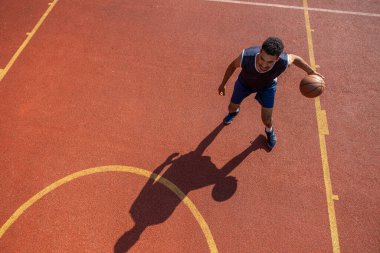 Sokak basketbolcusu dışarıda basketbol antrenmanı yapıyor..