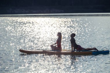 Kadın ve erkek yatakta yoga yapıyor ve birlikte meditasyon yapıyor..