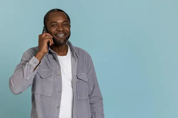 Gri Tişörtlü Mutlu Bir Zenci Cep Telefonuyla Konuşuyor Mavi Arka — Stok fotoğraf