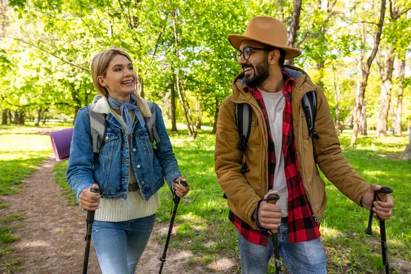 Traveling. Travelers with scandinavian sticks in a spring forest
