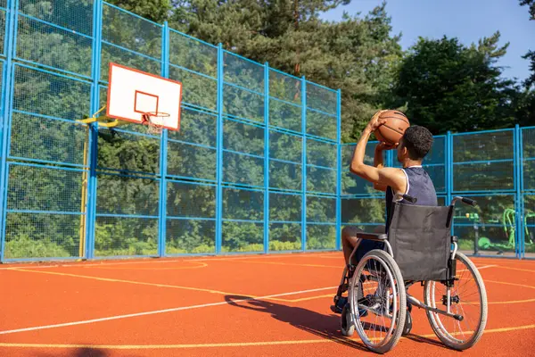 Black man with a disability in wheelchair at a park, has workout and weekend fun or active basketball match.