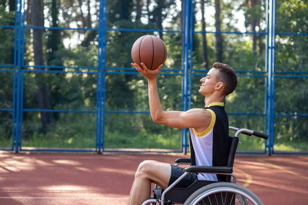Man with a disability in wheelchair at a park, has workout and weekend fun or active basketball match.