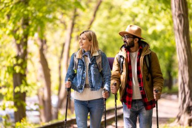 Parkta. Genç bir çift parkta yürüyor.