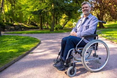 Kendine güven. Tekerlekli sandalyedeki adam mutlu ve kendinden emin görünüyor.
