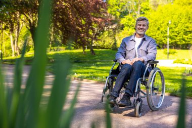 Kendine güven. Tekerlekli sandalyedeki adam mutlu ve kendinden emin görünüyor.