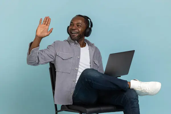 Kulaklıklı Heyecanlı Siyahi Adam Dizüstü Bilgisayarını Kullanarak Sallıyor Mavi Arka — Stok fotoğraf