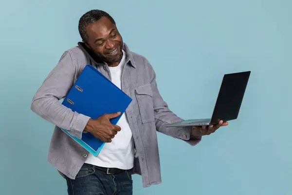 Akıllı Telefondan Konuşan Ofiste Çalışırken Dizüstü Bilgisayar Kullanan Gülümseyen Adam — Stok fotoğraf