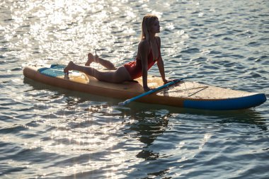 Çekici kadın yemek yogası kadın gerinerek deniz suyunda egzersiz yapıyor..