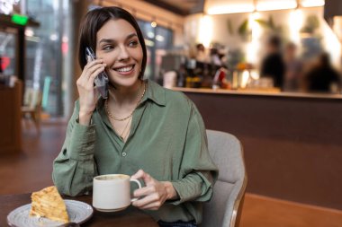 Bağlandı. Güzel bir kız telefonda konuşuyor ve memnun görünüyor.