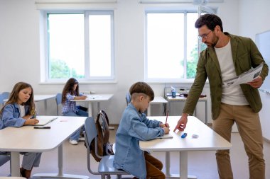 Okuldan bir ders. Okuldaki çocuklar derste oturuyor ve ilgili görünüyorlar.