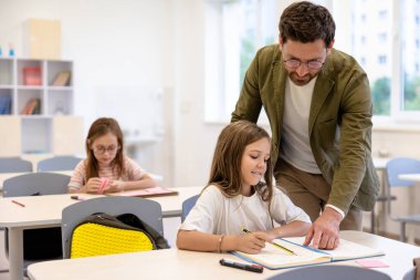 Yardımsever öğretmen. Sınav yazarken öğrencilere yardım eden erkek öğretmen