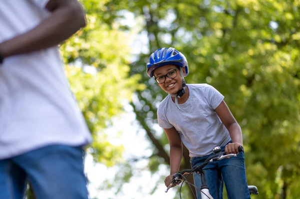 Ride in the park. Cute african american kids riding bikes in the park