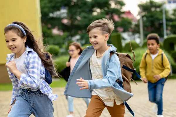 Okuldan sonra. Okul bahçesinde koşan mutlu çocuklar.