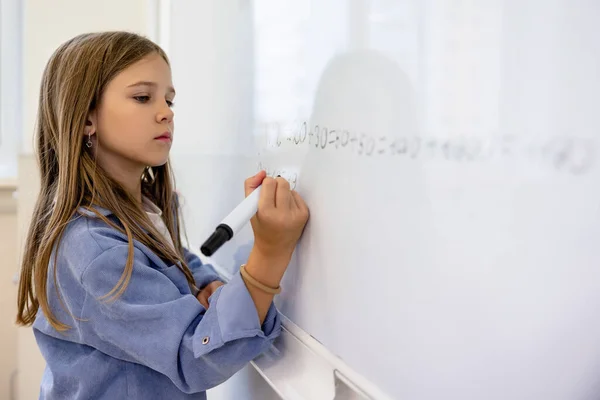 Bij Les Schattig Blond Schoolmeisje Schrijven Het Bord Kijken Geconcentreerd — Stockfoto