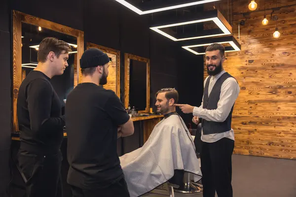 Professional barber teaches student to make mens hairstyles on model.