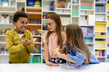 Okul kütüphanesindeki masada oturan çocuklar..