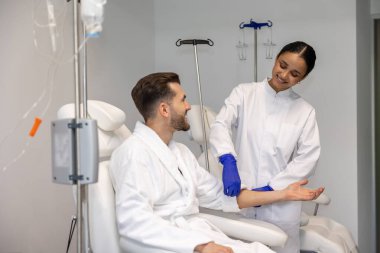 Damar içi vitamin tedavisi sırasında modern sağlık merkezinde sakallı bir adam..