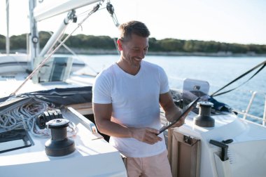 Teknedeki adam. Yatta beyaz giysili karizmatik bir adam.