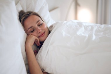 Huzurlu bir uyku. Uzun saçlı tatlı bir kız uyuyor ve huzurlu görünüyor.