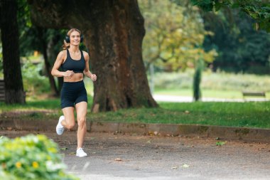 Yaz antrenmanı. Fitness sağlığı. Formda ve aktif. Parkta koşan sarışın atlet kadın..
