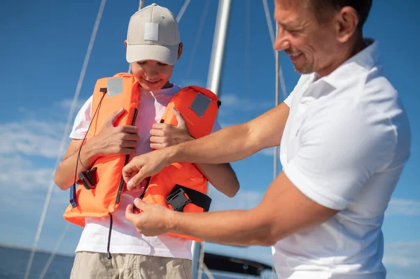 Yatçılık Babam Yatta Yelken Açarken Oğluna Can Yeleği Giydiriyor — Stok fotoğraf