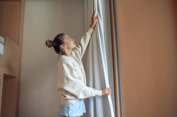 Hause Mädchen Weiß Steht Fenster Und Befestigt Den Vorhang — Stockfoto
