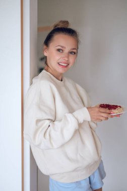 Kahvaltı vakti geldi. Saçlı genç kız kendine kahvaltı hazırlıyor.