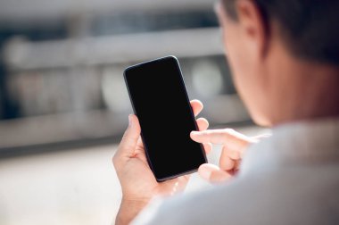 Reklam alanı ile boş ekran ile cep telefonu arayan yetişkin bir adamın arka planı.