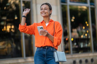 Sokakta yürürken cep telefonu kullanan şık bir esmer..