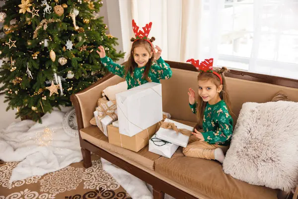 Δύο Αδερφές Πράσινα Πουλόβερ Και Ελάφια Ανοίγουν Χριστουγεννιάτικα Δώρα — Φωτογραφία Αρχείου