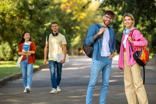 Молодые люди в парке. Группа молодых людей, гуляющих по парку