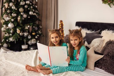 Tatlı ikizler uyumadan önce noel hikayeleri okuyorlar.