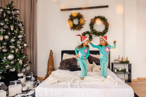 Cute Twins Pajamas Santa Hats Jumping Bed — Stock Photo, Image
