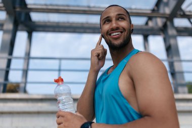 Sporcu. Koyu tenli, mavi spor giysili yakışıklı bir adamın belini kaldır.