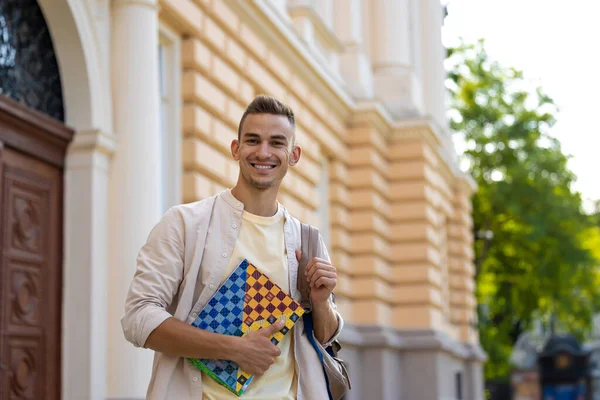 Vreugdevolle Student Glimlachende Jongeman Met Een Notitieboekje Handen Die Vrolijk — Stockfoto