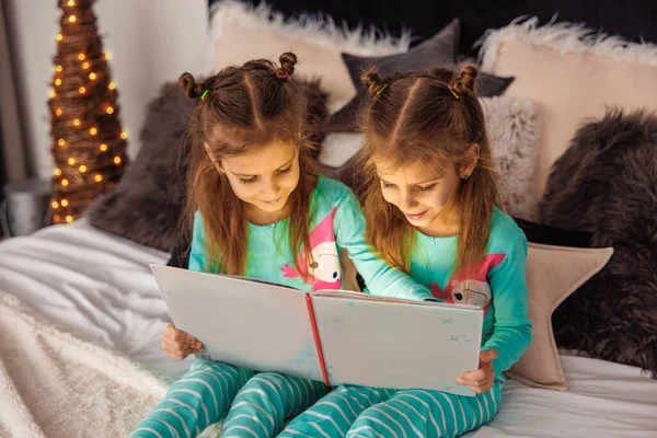 Cute twins reading christmas stories before sleep