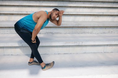 Esneklik. Merdivenlerdeki adam esneme hareketleri yapıyor.