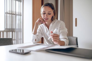 Çalışıyorum. Tatlı sarışın genç wo, belgelerle çalışıyor.