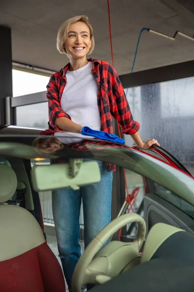 Υπηρεσία Αυτοκινήτων Νεαρή Χαμογελαστή Γυναίκα Καθαρίζει Αυτοκίνητο Και Αισθάνεται Καλά — Φωτογραφία Αρχείου