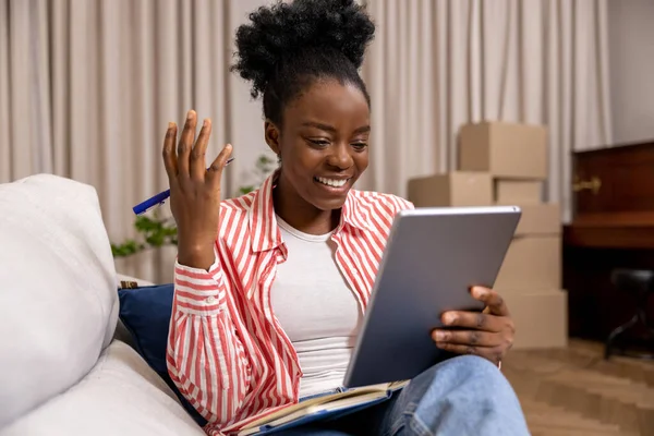 漂亮的黑人女性穿着数字平板电脑的休闲装 边上网边做笔记 — 图库照片