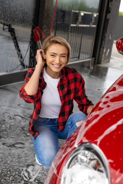 Πλύσιμο Αυτοκινήτου Χαμογελώντας Νεαρή Ξανθιά Γυναίκα Πλένει Ένα Αυτοκίνητο — Φωτογραφία Αρχείου