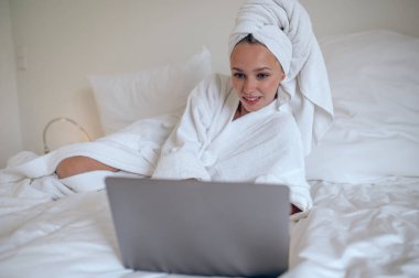 İnternetten randevulaşma. Genç bir kadın internette sohbet ediyor ve mutlu görünüyor.