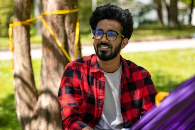 Hamaktaki adam rahat ve memnun görünüyor.